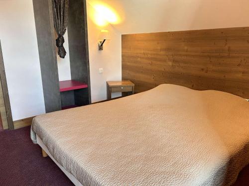 une chambre avec un grand lit avec une tête de lit en bois dans l'établissement Appartement 5 Pièces Cabine, 8 Couchages, Proche Pistes, Piscine, Sauna à Risoul 1850 - FR-1-330-589, à Risoul