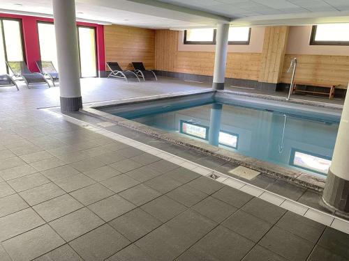 - une piscine dans un bâtiment avec des chaises et des tables dans l'établissement Appartement 5 Pièces Cabine, 8 Couchages, Proche Pistes, Piscine, Sauna à Risoul 1850 - FR-1-330-589, à Risoul
