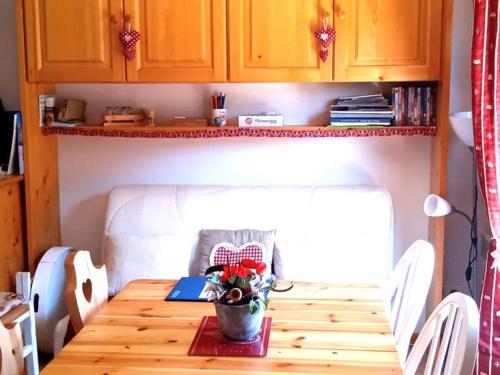 une petite cuisine avec une table en bois et un ordinateur portable dans l'établissement À louer : Appartement cosy 2 pièces cabine avec vue montagne - FR-1-573-138, à Le Biot