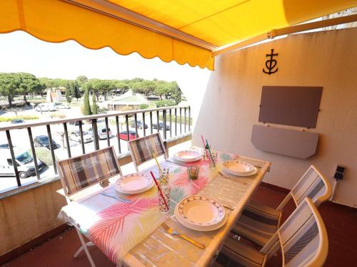 d'une table à manger avec des chaises et d'une télévision sur un balcon. dans l'établissement Studio ensoleillé à Port Camargue avec terrasse et parking - FR-1-307-283, au Grau-du-Roi