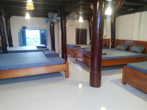 a room with three beds and a mirror at Vũ Gia Homestay in Ấp Bình Thạnh