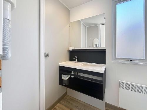une salle de bain avec un lavabo et un miroir dans l'établissement Mobil-home Grand Confort à 200m plage, camping avec piscine, terrasse, WiFi inclus - 4 pers. - FR-1-361A-37, à Jullouville