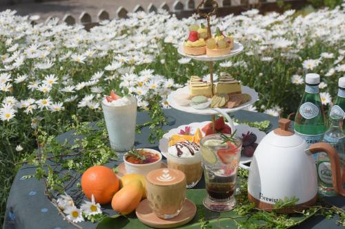 a table with desserts and drinks on it in a field of flowers at Dali Shuanglang seven-room sea view hotel in Dali Shuanglang
