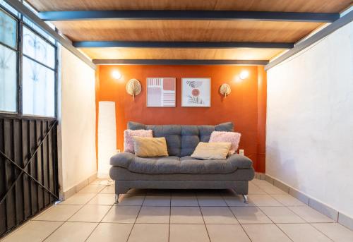 a couch in a living room with an orange wall at Best Location in Sayulita - Walk to Everything in Sayulita