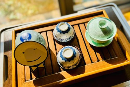 a wooden tray with four vases and cups on it at Dali Shuanglang seven-room sea view hotel in Dali Shuanglang