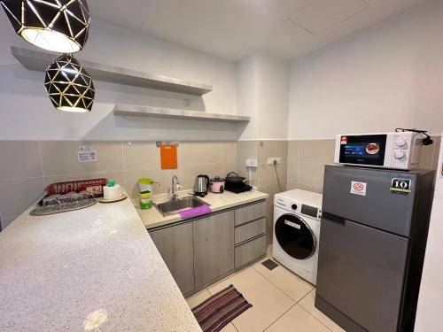 a small kitchen with a refrigerator and a dishwasher at SA Sutera Avenue Homestay Kota Kinabalu Area KK City Opposite Imago in Kota Kinabalu