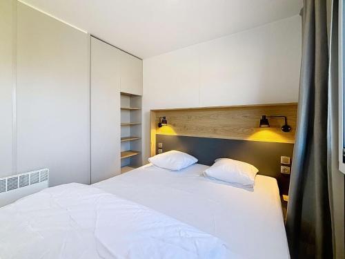 une chambre avec un grand lit blanc avec deux oreillers dans l'établissement Mobil-home confort 3 ch, piscine chauffée, 200m plage, parking, WiFi, animaux admis - FR-1-361A-72, à Jullouville