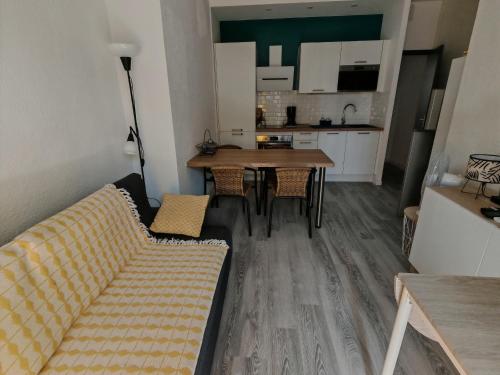 un salon et une cuisine avec un canapé et une table dans l'établissement Appartement moderne avec climatisation et parking au cœur de Canet Plage - FR-1-732-91, à Canet