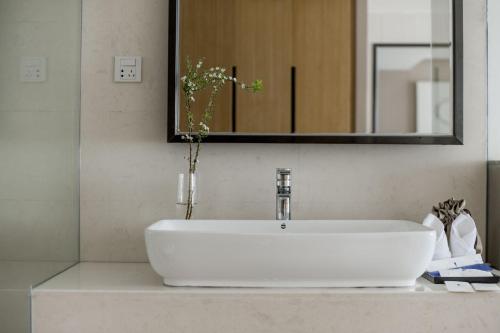 a white sink in a bathroom with a mirror at Dali Shuanglang seven-room sea view hotel in Dali Shuanglang