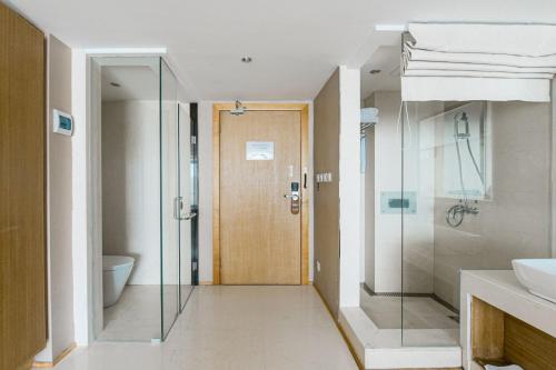 a bathroom with a shower and a glass door at Dali Shuanglang seven-room sea view hotel in Dali Shuanglang