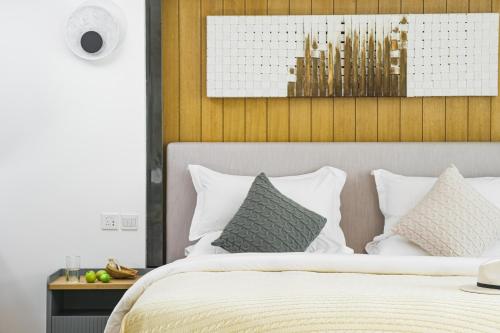 a bedroom with a bed with white sheets and pillows at Dali Shuanglang seven-room sea view hotel in Dali Shuanglang