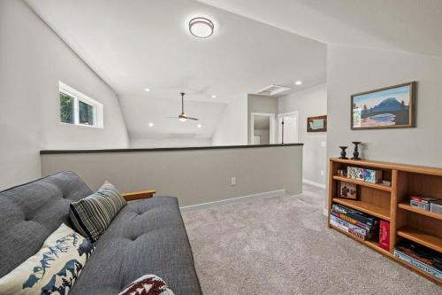 a living room with a couch and a book shelf at Rainier Cabin with Fireplace-WiFi-Yard-Meadow Views in Ashford