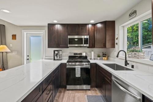 a kitchen with wooden cabinets and a stove top oven at Rainier Cabin with Fireplace-WiFi-Yard-Meadow Views in Ashford