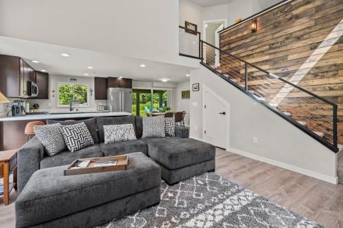 a living room with a couch and a staircase at Rainier Cabin with Fireplace-WiFi-Yard-Meadow Views in Ashford