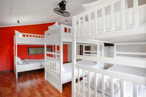 a room with white bunk beds and an orange wall at Luxurious 7BR Villa in Mui Ne with Private Swimming Pool in Ấp Thiện Phước