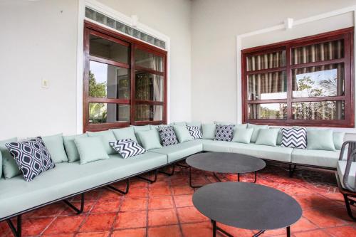 a living room with a large couch and two tables at Luxurious 7BR Villa in Mui Ne with Private Swimming Pool in Ấp Thiện Phước