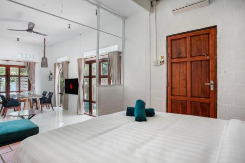 a bedroom with a white bed and a wooden door at Luxurious 7BR Villa in Mui Ne with Private Swimming Pool in Ấp Thiện Phước