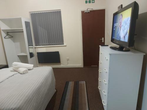 a bedroom with a tv on top of a dresser at Private 1 Bed Flat Near The Aston Villa Park in Birmingham