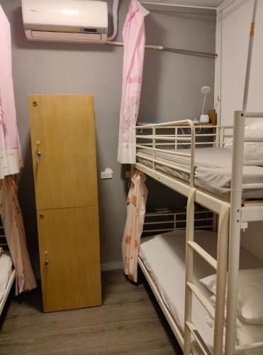 Schlafsaal mit Etagenbetten und einem Schrank in der Unterkunft Long River 82 Homestay in Taimali