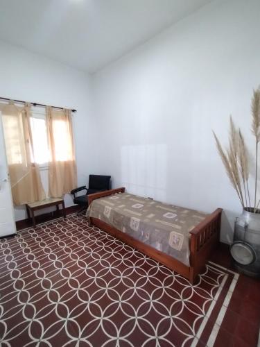 ein Schlafzimmer mit einem Bett und einem Teppich in der Unterkunft CASA PARA 4 PERSONAS, con asador y cochera in Cordoba