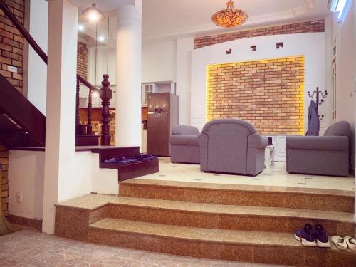 a lobby with stairs and chairs and a brick wall at BLUE with BALCONY 02 in Hanoi