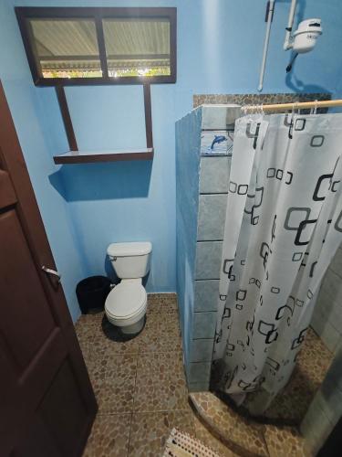 a bathroom with a toilet and a shower curtain at Ana Paraíso entre Arboles in Drake