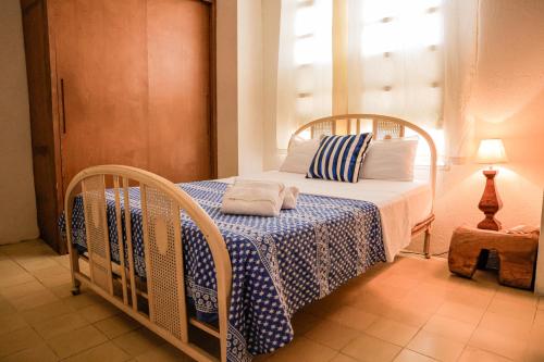 a bedroom with a bed with a blue and white blanket at Casa Zarah - Alma Hotels in Santa Marta