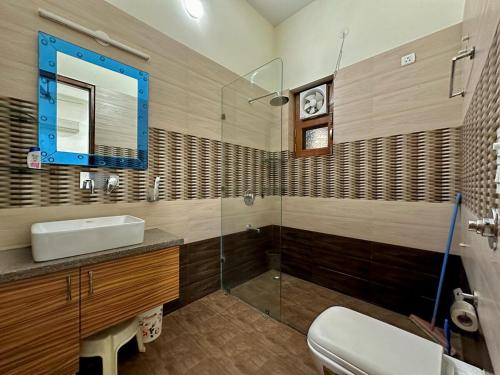 a bathroom with a sink and a glass shower at Nova Villa with Patio Escape in Amritsar