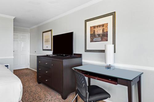 a bedroom with a desk with a television and a bed at The Morgan Hotel San Simeon in San Simeon