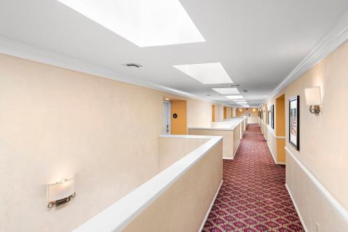 a corridor of a hospital room with white walls and red carpet at The Morgan Hotel San Simeon in San Simeon