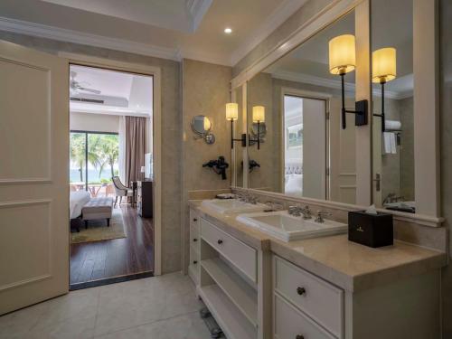 a bathroom with a sink and a large mirror at Vinpearl Wonderworld Phu Quoc in Phu Quoc