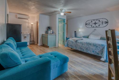 a living room with a blue couch and a bed at Enchanted Hideaway Cabins and Cottages in Ruidoso