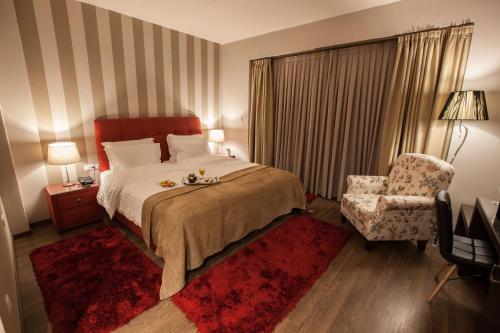 une chambre d'hôtel avec un lit et une chaise dans l'établissement Diamond City Living, à Dráma