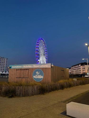 a large ferris wheel is lit up in the sky at L'Altéia - L'appartement les pieds dans l'eau avec place de parking privé et accès direct à la plage in Berck-sur-Mer