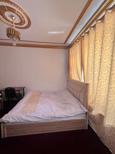 a small bed in a room with a window at Shahzadaguesthouse in Kabul