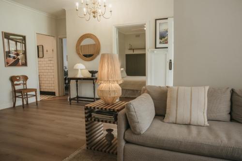 a living room with a couch and a table with a lamp at Harker House in Healesville