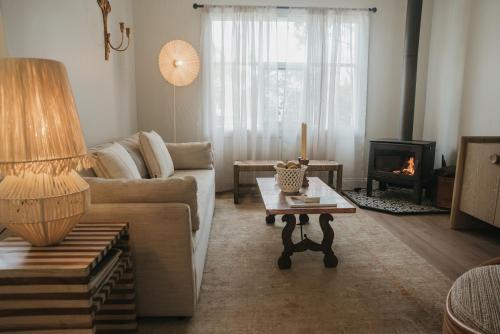 a living room with a couch and a fireplace at Harker House in Healesville