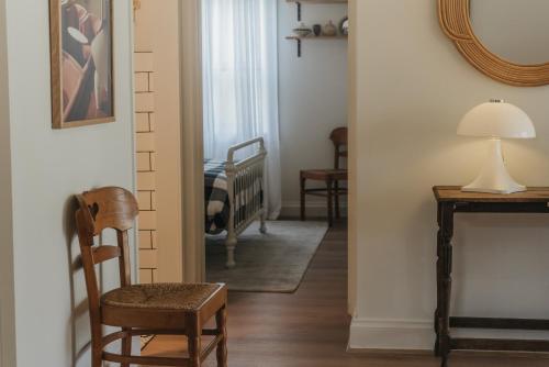 a hallway with a chair and a room with a crib at Harker House in Healesville