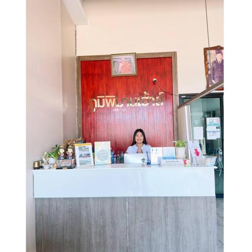 a woman sitting at a counter in a restaurant at ภูมิพิมานเฮ้าส์ in Udon Thani