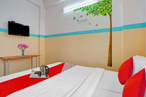 a room with a bed with a tree on the wall at SPOT ON The New View Regency in Trivandrum