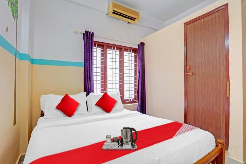 a bedroom with a large bed with red pillows at SPOT ON The New View Regency in Trivandrum
