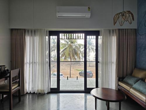 a living room with a couch and a table at illa - By the sea in Udupi