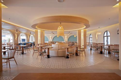 a large dining room with tables and chairs at Jomtien Thani Hotel in Jomtien Beach