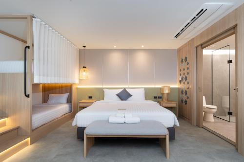 a bedroom with a large white bed and a bathroom at Jomtien Thani Hotel in Jomtien Beach