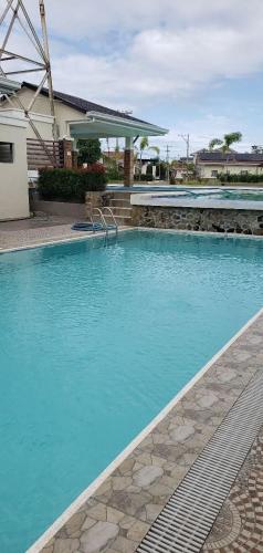 a swimming pool with blue water in front of a house at Hannah & Neil's Place-Panglao in Dao