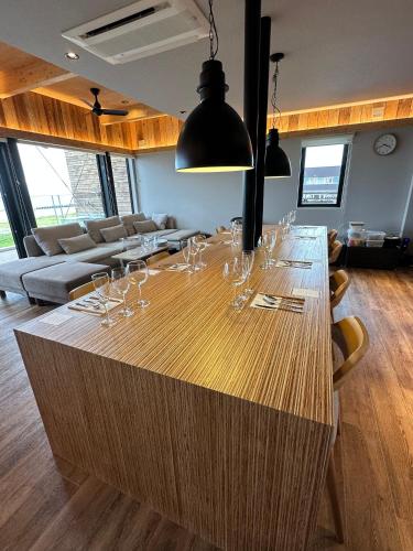 a large wooden table with wine glasses on it at ZABOCON YOICHI Villa in Yoichi