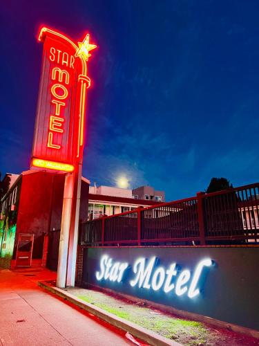 a sign for a star motel next to a fence at Star Motel in San Francisco