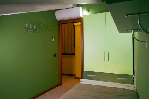 a room with green walls and a hallway with a door at Green Residence Sirmione in Desenzano del Garda