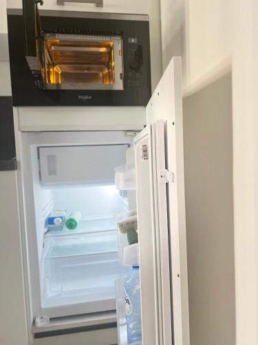 an open refrigerator with its door open and a microwave at visit Brussels city in Brussels