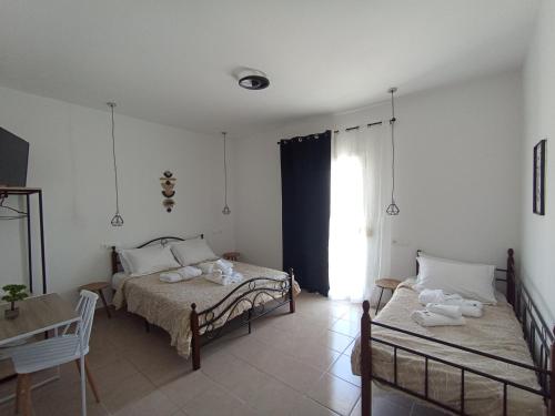 a bedroom with two beds and a window at ARTEMIS beach studios in Kalamaki Heraklion